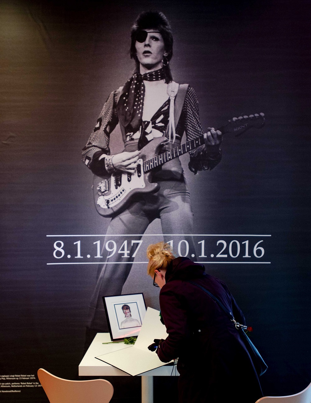 NED85 GRONINGEN (HOLANDA), 11/01/2016.- Una mujer firma en el libro de condolencias por la muerte del legendario músico británico David Bowie donde se exhibe la exposición "David Bowie is", en el museo de Groningen en Holanda, hoy, 11 de enero de 2016. Bowie, autor de clásicos como "Starman" y "Space Oddity", ha muerto hoy a los 69 años de cáncer. EFE/ROBIN VAN LONKHUIJSEN