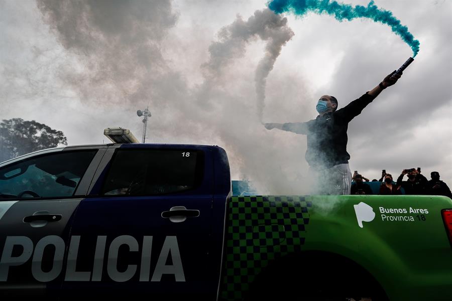 policía argentino en camioneta policial, con bengalas de humo en sus manos