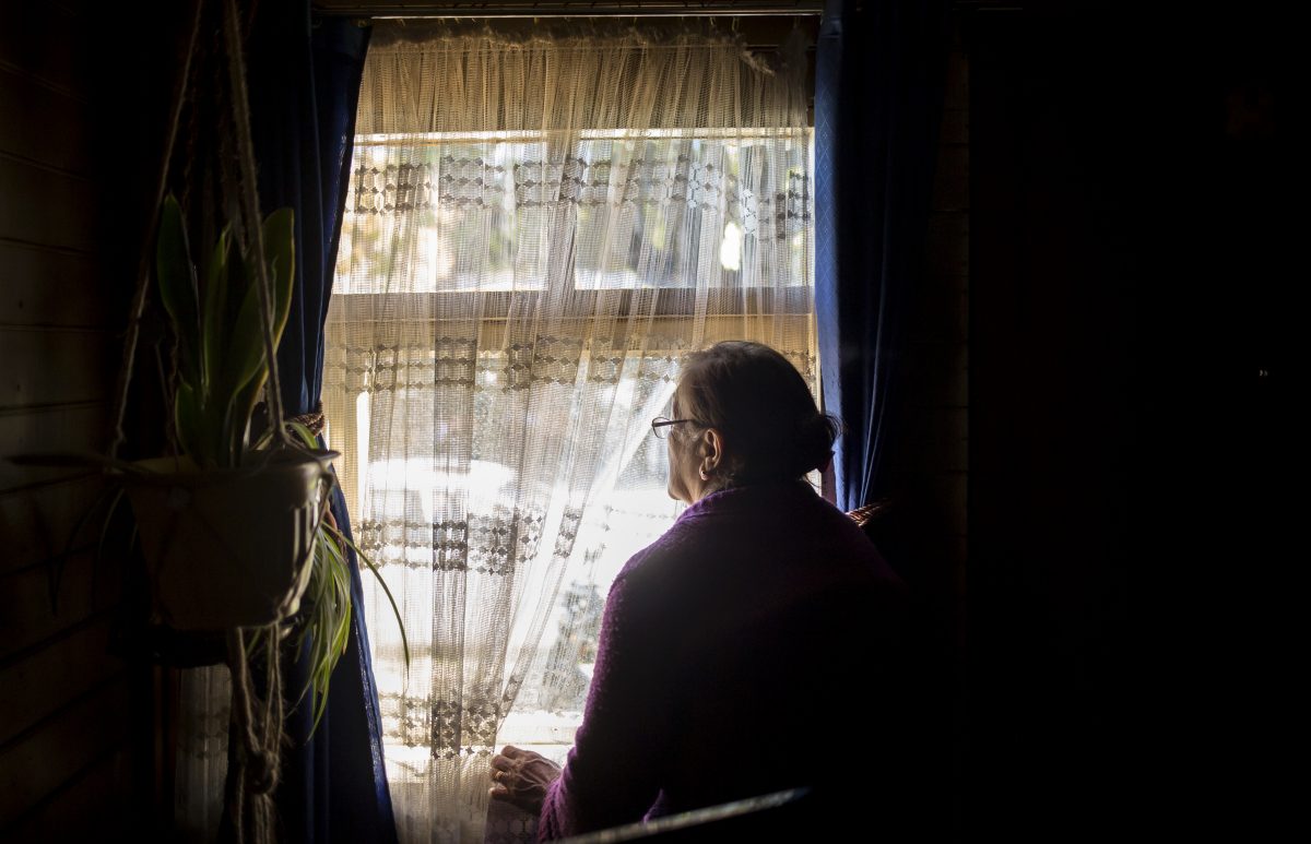 Una mujer observa la calle desde el interior de la ventana de su casa durante la novena semana de la cuarta cuarentena que ha tenido que vivir. 