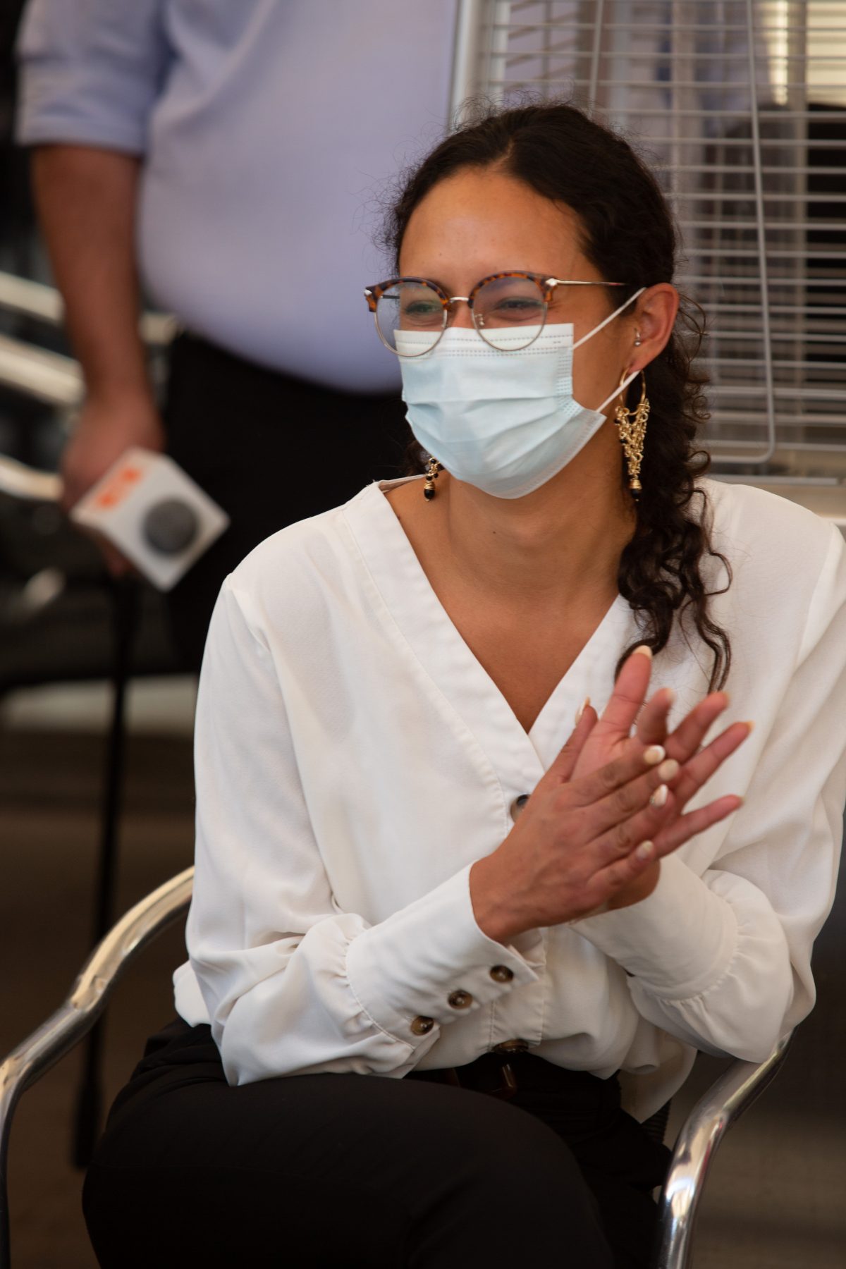 La imagen muestra a Javiera Reyes, con mascarilla, aplaudiendo.