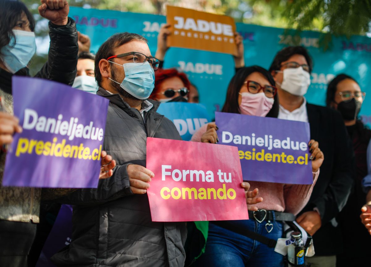 La imagen muestra a varias personas con carteles informativos sobre la campaña de Jadue. 