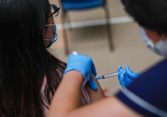 Una adolecente se vacuna contra el Covid-19 , en el centro de vacunacion Club Providencia.