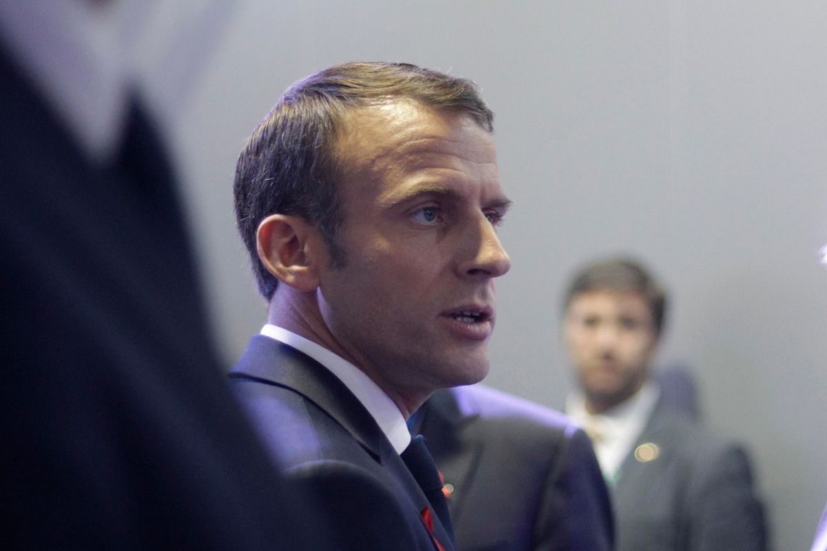 Emmanuel Macron, presidente de Francia, mira hacia la derecha con cara seria y la boca semiabierta, como queriendo decir algo.